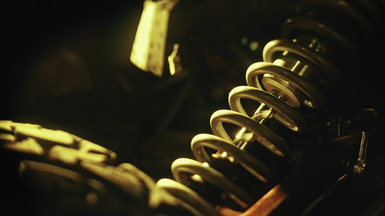 Close up of coil spring used as a part of car or motorcycle suspension system. Stock footage. Details of machines, professional equipment and repair parts