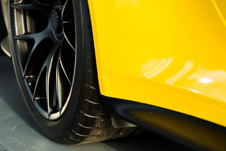 KYIV, UKRAINE - OCTOBER 7, 2019: selective focus of black car wheel in yellow porshe
